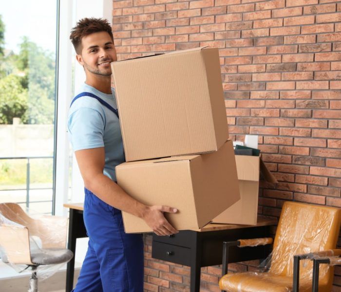 Young,Worker,Carrying,Cardboard,Boxes,In,Office.,Moving,Service